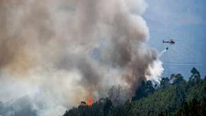 Um helicóptero de combate a incêndios faz uma descarga de água sobre as chamas, em Alvito da Beira, Proença-a-Nova, Castelo Branco, 15 de setembro de 2026. PAULO CUNHA/LUSA