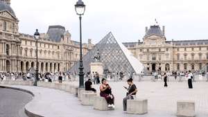 epa13119373 People enjoy the surrondings of the Louvre Museum in Paris, France, 18 July 2026.  EPA/TERESA SUAREZ
