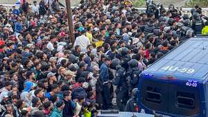 epa13247248 A group of migrants living at Benitez Beach wait to be transferred by Civil Guard members to a newly built pavilion in Ceuta, Spain, 18 September 2026. Spain is dealing with a massive migration crisis in the autonomous region of Ceuta after thousands of people crossed into the North African enclave from Morocco in late July 2026.  EPA/REDUAN