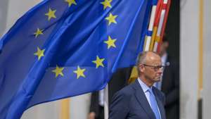 epa13117214 German Chancellor Friedrich Merz stands in front of a European flag during military honor guard in front of the Augustusburg castle at the 26th German-French Ministerial Council in Bruehl, Germany, 17 July 2026. The German and French governments are meeting in Bruhl to discuss a range of bilateral and international topics.  EPA/SASCHA SCHUERMANN / POOL