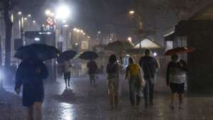 epa13279504 Passers-by walk along a street during heavy rainfall in Barcelona, Catalonia, northeastern Spain, 03 October 2026.  EPA/Alejandro Garcia
