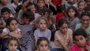 epaselect epa13308021 Internally displaced Palestinian children watch a movie at a makeshift open-air cinema near the ruins of destroyed buildings in the Al-Sheikh Redwan neighborhood in Gaza City, 15 October 2026. Around 1.9 million people in Gaza, nearly 90 percent of the population, have been displaced since the Israel-Hamas conflict began in October 2023, according to the UN.  EPA/MOHAMMED SABER