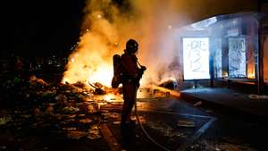 epa13314531 A French firefighter responds to a street barricade burns as clashes between riot police and demonstrators continue for the second day during nationwide protests against the high cost of living in Paris, France, 18 October 2026.  EPA/MOHAMMED BADRA