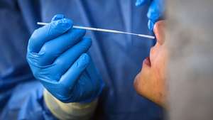 epa08811788 A Healthcare worker, wearing a protective suit, performs a Covid-19 swab test at the Roma Termini Binario95 social hub test center, during the Coronavirus Covid-19 pandemic emergency in Rome, Italy, 10 November 2020. The social hub Binario95, located at the central Roma Termini station, provides coronavirus tests for homeless people, care workers and volunteers.  EPA/ANGELO CARCONI  ATTENTION: This Image is part of a PHOTO SET
