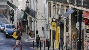 Um turista atravessa a rua da Madalena na zona da baixa pombalina de Lisboa, 20 de novembro de 2020. A falta de turismo na cidade de Lisboa devido à pandemia de Covid 19 levou a que muitos estabelecimentos comerciais, alguns deles emblemáticos e de familias há gerações estejam em risco de fechar. (ACOMPANHA TEXTO DA LUSA DE 22 DE NOVEMBRO DE 2020) TIAGO PETINGA/LUSA