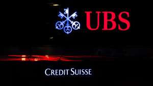 epa10529298 The illuminated logos of the Swiss banks Credit Suisse and UBS are displayed on buildings in Zurich, Switzerland, 18 March 2023. Shares of Credit Suisse lost more than one-quarter of their value on 15 March, hitting a record low after its biggest shareholder, the Saudi National Bank, told outlets that it would not inject more money into the ailing Swiss bank.  EPA/MICHAEL BUHOLZER