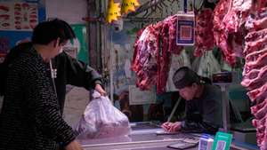 epa11332412 People buy food at a meat shop in a market in Beijing, China, 11 May 2024. According to the report by the National Bureau of Statistics on 11 May, China's Consumer Price Index (CPI) stood at 0.3 percent year on year in April 2024.  EPA/WU HAO