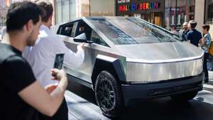 epa11314391 Passers-by stand in front of the Tesla Cybertruck, on display at the Mall of Berlin shopping mall, in Berlin, Germany, 02 May 2024. The Tesla Cybertruck will be on display in Berlin from 02 to 04 May 2024 and afterward in over 100 locations across 20 countries.  EPA/CLEMENS BILAN