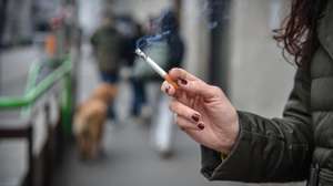 epa11802367 A woman smokes a cigarette on a street in Milan, Italy, 02 January 2025, following the city's new smoking regulations that took effect on 01 January. Smokers must now be at least ten meters away from others when smoking outdoors or face fines ranging from 40 to 240 euros.  EPA/MATTEO CORNER