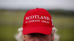 epa12262213 A person wears a 'Scotland is Already Great' hat outside Prestwick Airport ahead of the arrival of the US President in Glasgow, Scotland, Britain, 25 July 2025. President Trump is due to visit Scotland where he will visit his golf courses and meet with UK Prime Minister Keir Starmer.  EPA/TOLGA AKMEN