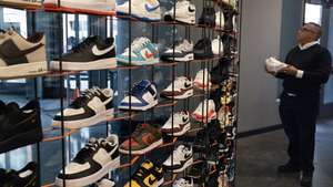 epa11159457 A customer looks at Nike shoes for sale at a store in Washington, DC, USA, 16 February 2024. Nike will begin cutting two percent of the company's current workforce, or over 1,500 jobs, as part of a restructuring plan to cut costs by two billion USD over three years, according to company statement.  EPA/MICHAEL REYNOLDS