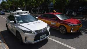 epa11623410 A taxi passes by a self-driving taxi in Daxing district in Beijing, China, 02 September 2024 (issued 25 September 2024). China's capital Beijing initiated the autonomous driving demonstration area in September 2020, and approved the commercial operation of fully autonomous driving services in Beijing E-Town in March 2023. By the end of 2023, over 30 Chinese cities had issued road test licenses for autonomous driving, Wuhan had opened 3,379 km of one-way testing roads across 3,000 square km, benefiting 7.7 million local residents. Pony.ai deployed around 250 robotaxis in China's Beijing, Shanghai, Guangzhou and Shenzhen, around 100 of which are now available in the autonomous driving zone in Beijing, offering paid services for passengers. China's robotaxis service is expected to reach 1.3 trillion yuan (165.22 billion euros) by 2030, according to forecasts from the global consultancy firm IHS Markit.  EPA/WU HAO