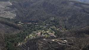 Uma aldeia cercada por floresta queimada na Serra do Caramulo, onde 70% da totalidade dos baldios de Préstimo, em Águeda, ardeu neste incêndio, devido ao fogo do incêndio que teve início em Vouzela, 9 de julho de 2026. (ACOMPANHA TEXTO DO DIA 11 DE JULHO DE 2026) PAULO NOVAIS/LUSA
