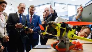 epa13177013 German Interior Minister Alexander Dobrindt (2-L), flanked by German Minister of Research, Technology and Space Dorothee Baer (L) and Saxony-Anhalt State Premier Sven Schulze (3-L), receives explanations on drones with fake explosive add-ons during the inauguration of a new drone safety technology center at the DLR site in Cochstedt district of Hecklingen, Germany, 18 August 2026. The newly opened drone security research center aims to enhance the safety and resilience of unmanned aerial systems, following an early-August 2026 incident where an explosive-laden drone was discovered near active runways at Leipzig/Halle Airport.  EPA/CLEMENS BILAN