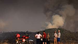 Local people watch the flames and smoke of a forest fire, which started in Torre de Moncorvo and spread to the municipality of Carrazeda de Ansiães, in Vilarinho da Castanheira, Portugal, 17 August 2026. PEDRO SARMENTO COSTA/LUSA