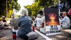 epa13148325 Demonstrators take part in a silent si-in blockade at the main gate of Volkel military air base in Volkel, Netherlands, 03 August 2026. The demonstrators block the entrance to commemorate the atomic bombs dropped on Hiroshima and Nagasaki 81 years ago and to and to protest against the presence of nuclear weapons at the base.  EPA/ROB ENGELAAR