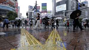 epa13251186 Pedestrians with umbrellas walk at Shibuya crossing under rainfall in Tokyo, Japan, 20 September 2026. Powerful Typhoon Dujuan is expected to approach eastern Japan, including the Tokyo area, bringing torrential rain. The Japan Meteorological Agency warned that some areas could receive a month’s worth of September rainfall in a single day.  EPA/FRANCK ROBICHON