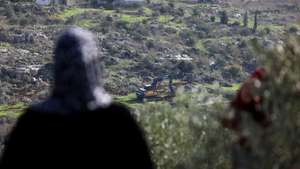 epa12608765 Palestinians watch as Israeli bulldozers level agricultural lands in the town of Silat al-Harithiya, near the West Bank city of Jenin, 22 December 2025. According to the Palestinian news agency Wafa, Mayor Samir Zayoud stated that the machinery began leveling farmlands early in the morning in the al-Suruj area, situated between Silat al-Harithiya and Ya'bad.  EPA/ALAA BADARNEH