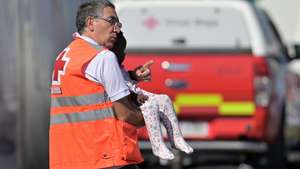 epa11575299 A Red Cross member holds a migrant child in his arms as 174 migrants who have been rescued in the waters off El Hierro and transferred to the port of La Restinga, arrive in El Pinar, El Hierro, Canary Islands, Spain, 31 August 2024.  EPA/GELMERT FINOL