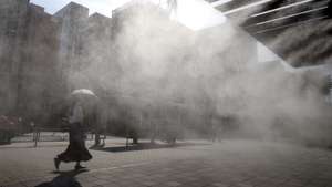 epa12258181 A passerby walks past a cooling mist station during a heatwave in Tokyo, Japan, 24 July 2025. Temperatures are surging across Japan, with a high of 39.4 degrees Celsius recorded in Kyoto Prefecture, western Japan, according to the Japan Meteorological Agency (JMA).  EPA/FRANCK ROBICHON