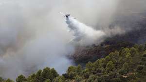 epaselect epa13157806 An aircraft drops water to extinguish a forest fire in Tirig, Castellon, Spain, 09 August 2026. The fire, which started 07 August 2026, has forced dozens of residents of Cati to shelter in place as efforts continue to put out the fire, which has already burned some 244 hectares.  EPA/ANA ESCOBAR