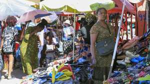 Comerciantes e populares numa rua do distrito urbano do Palanca, município do Kilamba Kiaxi, em Luanda, onde grande parte da comunidade congolesa em Angola reside há décadas, e aí mesmo buscam o seu ganha-pão, que vai desde a venda de refeições diversas e bebidas em bares na berma das estradas, bem como roupa usada, material elétrico, de construção e outros, em Luanda, Angola, 09 de janeiro de 2024. Perto de cinco milhões de congoleses da República Democrática do Congo (RDCongo) vivem em Angola, segundo estimativas dos líderes da comunidade em Angola, maioritariamente dedicados ao comércio a grosso de retalho de produtos diversos, sobretudo no mercado informal. (ACOMPANHA TEXTO DA LUSA DO DIA 14 DE JANEIRO DE 2024). AMPE ROGÉRIO/LUSA