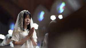 epaselect epa12290582 A churchgoer prays during an early morning mass at Urakami Cathedral in Nagasaki, Japan, 09 August 2025, the day of the 80th anniversary of the atomic bombing. In 1945, the United States dropped two nuclear bombs over the cities of Hiroshima and Nagasaki on 06 and 09 August, respectively, killing more than 200,000 people.  EPA/FRANCK ROBICHON