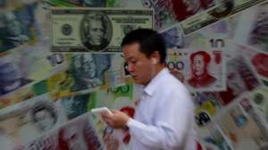 epa02333461 A man walks past oversize Chinese yuan (RMB) notes, US bank notes and other foreign currency are seen out side a foreign exchange in Hong Kong, China 13 September 2010. The Chinese yuan currency rose to a record high on 13 September after US Secretary Timothy Geithner said China has made very little progress to let the yuan exchange rate reflect market forces.  EPA/YM YIK