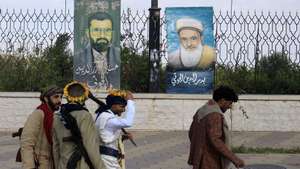 epa13221042 Armed people walk past paintings depicting late Houthi leaders on display on a fence in Sana'a, Yemen, 07 September 2026. United Nations Special Envoy for Yemen Hans Grundberg warned of grave consequences for civilians in Yemen due to the recent escalation of fighting between the Houthis and government forces, calling on the warring parties to prevent further escalation.  EPA/YAHYA ARHAB