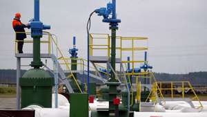 epa00900068 A worker stands on a platform at the first pump station on Belarus territory of the Druzhba pipeline, near the village of Bobovichi, about 330 km southeast of Minsk, Thursday, 11 January 2007. One of two German refineries hit by the suspension of Russian oil deliveries started receiving supplies again Thursday after Russian pipeline monopoly Transneft resumed pumping.  A spokesman for the PCK refinery in Schwedt said crude oil from the Druzhba (friendship) pipeline through Belarus started reaching the processing facility on Thursday morning.  EPA/ANDREI LIANKEVICH