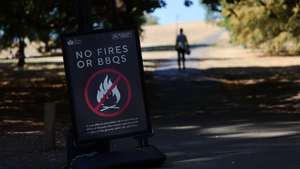epa13163228 A sign indicating no fires or BBQs at a parched parkland at Primrose Hill in London, Britain, 12 August 2026. An amber heat alert has been issued for most of southern UK as another heatwave sweeps across the UK. Meanwhile, 2026 is on course to be Britain's hottest summer ever recorded, the Met Office has reported.  EPA/ANDY RAIN