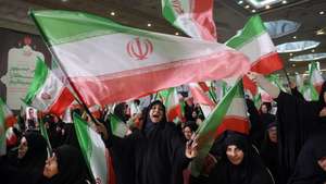 epaselect epa12749570 Iranian women wave Iran's national flags during  a memorial ceremony for those killed in anti-government protests earlier last month, at the Mosallah mosque in Tehran, Iran, 17 February 2026. Following US military threats against Iran, Iranian supreme leader Ayatollah Ali Khamenei said on 17 February 2026, that the US and its president could not destroy Iran, adding that the 'strongest military force in the world may at times be struck so hard that it cannot get up again'  EPA/ABEDIN TAHERKENAREH