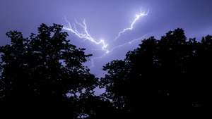 epa09343244 A view of lightning in the sky as a thunder storm hits Berlin, Germany, 14 July 2021. Summer thunderstorms with heavy rain fall hit eastern parts of Germany.  EPA/FILIP SINGER