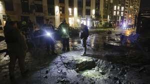 epa13299378 Ukrainian rescuers inspect a crater at the site of a Russian drone strike on a residential area in Kyiv, Ukraine, 12 October 2026, amid the ongoing Russian invasion. At least two people died and 9 other people, including one child, were injured in the Russian drone strike on the residential area in Kyiv, according to the State Emergency Service report.  EPA/SERGEY DOLZHENKO