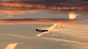 epa05057949 A jumbo jet has lowered its landing gear and is ready to come in to the city airport before the backdrop of the morning sky tinted by the rising sun in Frankfurt am Main, Germany, 07 December 2015.  EPA/FRANK RUMPENHORST