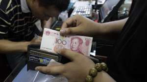 epa04881886 A Chinese customer at the front of a queue shows this photographer a 100 Chinese Yuan, or Renminbi, bill at a convenience store in Beijing, China, 13 August 2015. China's central bank on 13 August devalued the yuan for the third time in three days, to aid a slowing economy. The People's Bank of China unexpectedly adjusted its daily reference exchange rate by a further 1.1 per cent, setting it at 6.4010 to the US dollar.  EPA/ROLEX DELA PENA
