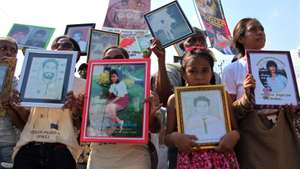 epa05021465 East Timorese carry potraits of Santa Cruz massacre victims during a commemoration ceremony in Dili, East Timor, also known as Timor Leste, 12 November 2015. Hundreds of East Timorese commemorated the pro-independence demonstrators who were killed at Santa Cruz graveyard 24 years ago.  EPA/ANTONIO DASIPARU