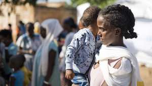 epaselect epa08858036 An Ethiopian refugee woman with her child from Tigray region wait to receive aid at the Um Rakuba refugee camp, the same camp that hosted Ethiopian refugees during the famine in the 1980s, some 80 kilometers from the Ethiopian-Sudan border in Sudan, 01 December 2020 (issued 02 December 2020). According to World Food Programme on 02 December, about 12,000 Ethiopian refugees from Tigray are accomodated in the Um Rakuba camp as over 40,000 Ethiopian refugees fleed to Sudan since the start of fights in the northern Tigray region of Ethiopia. Ethiopia's military intervention   comes after Tigray People's Liberation Front (TPLF) forces allegedly attacked an army base on 03 November 2020 sparking weeks of unrest. According to reports on 02 December 2020, UN reached an agreement with Ethiopian government to provide aid for the Tigray region of Ethiopia.  EPA/ALA KHEIR