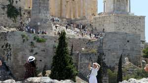 epa12200837 Tourists pose for photos in front of the Acropolis amid a heatwave in Athens, Greece, 27 June 2025. Very high maximum temperatures are expected, in places over 40 degrees Celsius, on 27 June, according to the latest forecast data from the National Observatory of Athens.  EPA/ALEXANDROS VLACHOS