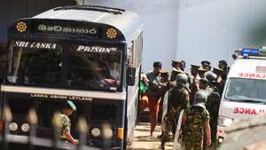 epa13091569 Security personnel escort prisoners to a bus at Negombo Prison on the outskirts of Colombo, Sri Lanka, 06 July 2026. Clashes at the prison have killed 25 people, including four prison guards, and wounded more than 100 following overnight clashes between inmates from two drug gangs at the area's main prison, according to police officials.  EPA/STRINGER