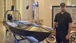 epa11417238 A Ukrainian security officer stands near a model of the new Ukrainian maritime drone 'Stalker 5.0' at the international 'Black Sea Security Forum 2024' in Odesa, southwestern Ukraine, 16 June 2024 (issued 17 June 2024). Ukraine's latest Marine Unmanned Surface Vehicle (MUSV) 'Stalker 5.0' was unveiled during the international 'Black Sea Security Forum 2024' in Odesa. The five meter long and 1.2 meter wide drone is capable of delivering water, food, military equipment and other cargo to islands or coastal areas. It can also be used for surveillance and coastal patrols in sea and river border areas.  EPA/IGOR TKACHENKO