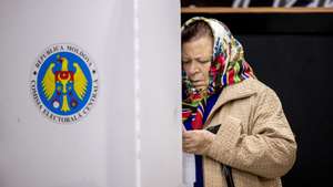 epaselect epa11671930 A woman examines her ballot paper in a polling station in Hrusevo village, Moldova, 20 October 2024. Moldova holds presidential election and a referendum on whether to enshrine in the Constitution the country&#039;s path to EU membership on 20 October.  EPA/DUMITRU DORU