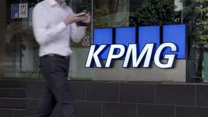 epa08777182 A man walks past the logo of auditing firm KPMG in the financial district in Singapore, 27 October 2020. The fallout of the global Covid-19 coronavirus pandemic has had a range of effects across workers from different sectors of the economy. As businesses gradually open up, economists are describing a 'K-shaped' recovery caused by lower wage workers affected by health and safety regulations, while white collar workers remain largely unaffected due to the advent of telecommuting and work from home arrangements.  EPA/WALLACE WOON