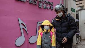 epa10464283 A child escorted by a parent enters their school in Shanghai, China, 13 February 2023. After the Chinese New Year holiday and online classes for three years, students in China are back on campuses. According to the latest guidebook on epidemic prevention and control, schools can restore on-site teaching if there are no COVID-19 cases. Students and school personnel will undergo seven days of health monitoring and minimise gatherings.  EPA/ALEX PLAVEVSKI