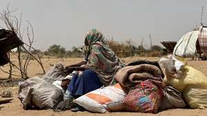 epa12049103 A Sudanese woman, who fled from the internally displaced persons (IDP) Zamzam camp, rests while on her way to the Tawila Camps amid the ongoing conflict between Sudan's army and the Rapid Support Forces (RSF), in North Darfur, Sudan, 23 April 2025. The RSF claimed control of the Zamzam camp after its assault in April 2025. According to the UNHCR, over four million people have fled Sudan to neighboring countries since the outbreak of the armed conflict in April 2023.  EPA/MARWAN MOHAMED