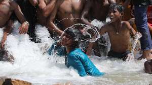 epa11381757 Indian people take bath in water which was flowing into a lake on hot day in New Delhi, India, 31 May 2024. The India Meteorological Department (IMD) has issued a heat red alert for Delhi, Rajasthan, Haryana, Punjab, and Madhya Pradesh. The IMD Director General M Mohapatra said they are checking the temperature sensor in Delhi's Mungeshpur automatic weather station to see if it is working properly, as there were temperatures of over 50 degrees Celsius recorded on 29 May, and the weather department has reported that the maximum temperature is anticipated to reach around 44 degrees Celsius, in the Indian capital.  EPA/RAJAT GUPTA