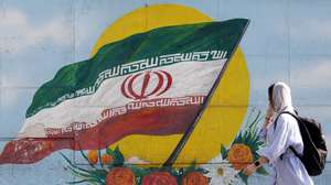 epa10295546 A woman walks past a graffiti showing the Iranian national flag in Tehran, Iran, 09 November 2022. Iran has been rocked by anti-government protests, with supporters worldwide, following the death in September 2022 of Masha Amini, a 22-year-old girl who died while in police custody after being detained for breaking Iran's strict dress code for women. Iranian leaders condemned the protests and accused the United States and Israel of planning the uprising.  EPA/ABEDIN TAHERKENAREH
