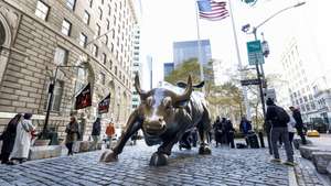 epa07981927 People walk past the 'Charging Bull' statue in the Bowling Green area of New York, New York, USA, 08 November 2019. The city is planning on moving the statue, which is a popular tourist attraction, from its current location on an island between two streets to a new site near the New York Stock Exchange.  EPA/JUSTIN LANE