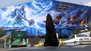 epa13238501 An Iranian woman walks next to an anti-US billboard reading in Persian 'The devil army will be drown in the Persian Gulf' at the Enghelab square in Tehran, Iran, 14 September 2026. The Iranian foreign ministry said a planned meeting in Oman over the Strait of Hormuz involving foreign ministers from Gulf countries and Tehran was postponed as conflict continues between Iran and the US.  EPA/ABEDIN TAHERKENAREH RESTRICTIONS: NO Access Israel Media/Persian Language TV Stations Outside Iran/Strictly No Access BBC Persian/VOA Persian/Manoto TV/Iran International TV. (As mandated by Iran's Directorate General for Foreign Media) --