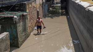 epa12364712 A man wades through mud gathered outside houses as the Yamuna River water recedes after flooding in the Yamuna Bazar area in New Delhi, India, 09 September 2025. The Yamuna River water level continues to recede, with the level dropping to 205.47 meters, slightly above the danger level, which is 205.33.  EPA/RAJAT GUPTA